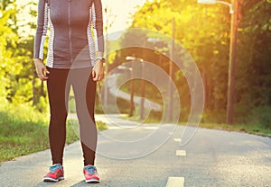 Female athlete preparing for a jog on a forest path