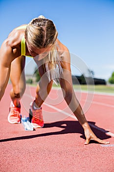 Female athlete ready to run on running track