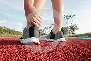 Female Athlete Runner Ankle Injury While Jogging in Running Track, Sport Woman Having Pain Her Ankles During Exercise Running.