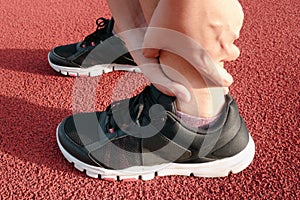 Female Athlete Runner Ankle Injury While Jogging in Running Track, Sport Woman Having Pain Her Ankles During Exercise Running.