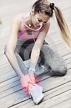 Female athlete runner touching foot in pain outdoors