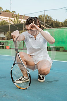 female athlete squats in despair when she loses playing