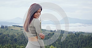 Female athlete standing outdoors and enjoying mountains view