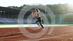 Female athlete starting her sprint on a running track. Runner taking off from the starting blocks on running track