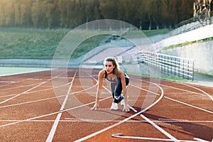 Female athlete starting her sprint on a running track. Runner taking off from the starting blocks on running track