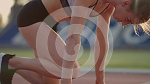 Female athlete starting her sprint on a running track. Runner taking off from the starting blocks on running track