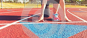 Female athlete on the starting line of a stadium track