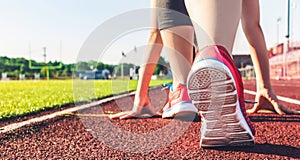 Female athlete on the starting line of a stadium track