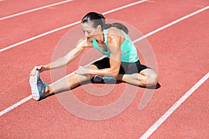 Female athlete stretching her hamstring