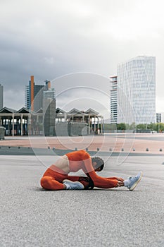 Female athlete stretching leg before running. Young caucasian woman morning workout routine. Vertical image