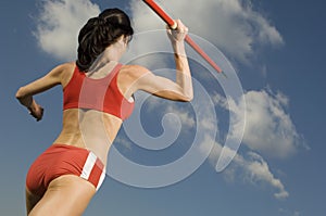 Female Athlete Throwing Javelin Against Sky
