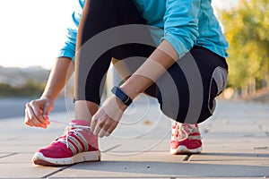 Female athlete tying laces for jogging.