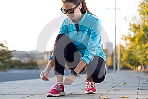 Female athlete tying laces for jogging.