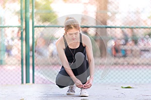Female athlete tying laces for jogging