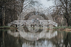 Female athletes exercising on a picturesque bridge in a serene park setting