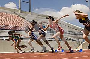 Female Athletes Taking Off From Starting Blocks