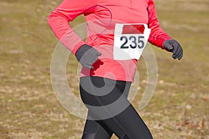 Female athletic runner on a cross country race. Outdoor circuit