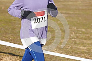 Female athletic runner on a cross country race. Outdoor circuit