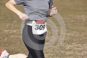 Female athletic runner on a cross country race. Outdoor circuit