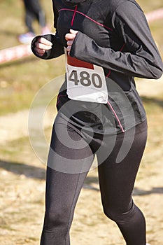 Female athletic runner on a cross country race. Outdoor circuit