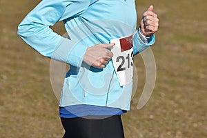 Female athletic runner on a cross country race. Outdoor circuit