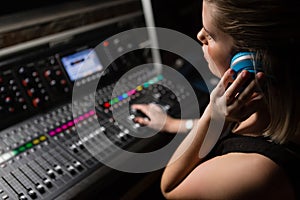 Female audio engineer using sound mixer