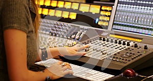 Female audio engineer using sound mixer