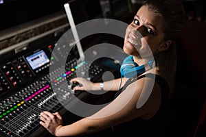 Female audio engineer using sound mixer in recording studio