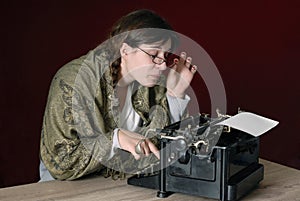 Female author typing on an old typewriter