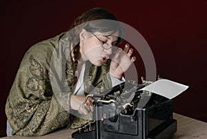 Female author typing on an old typewriter