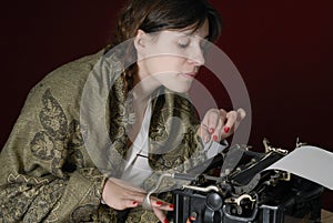 Female author typing on an old typewriter
