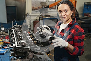 Female auto mechanic fixing car engine in repair service station