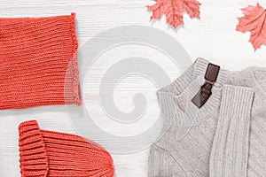 Female autumn clothing, warm knitted scarf and cap pink trend colored and light woolen beige jamper.