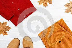 Female autumn clothing, warm wool red jumper and orange trousers from corduroy and comfort boots