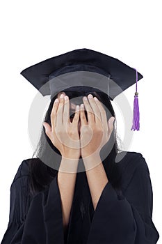 Female bachelor with graduation gown peeking