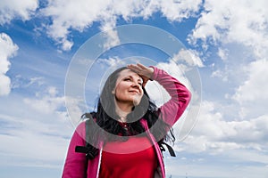 Female with backpack enjoying the view while standing on the top