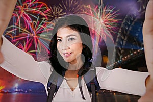 Female backpacker taking selfie in fireworks party