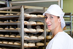 Female baker baking bread rolls