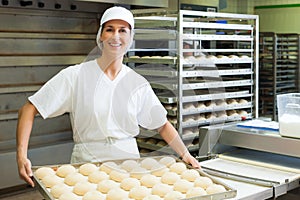 Female baker baking bread rolls