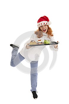 Female baker chef with hat of Santa Claus dancing with Christmas