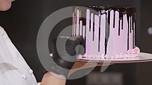 Female baker is decorating a birthday cake with tiny marshmellows