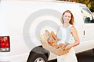 Female Baker Delivering Bread Standing In Front Of Van