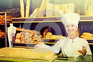 Female baker with fresh bread in bakery