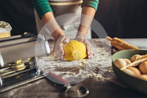 Female baker hands kneading the dough with flour powder