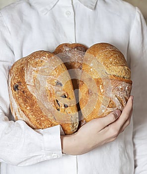 Female baker holds home made artisan organic bread fresh from the oven. Homemade sourdough bread. Homemade food