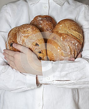 Female baker holds home made artisan organic bread fresh from the oven. Homemade sourdough bread. Homemade food