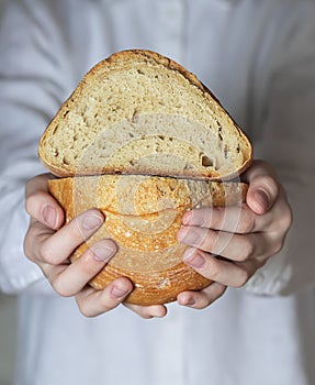 Female baker holds home made artisan organic bread fresh from the oven. Homemade sourdough bread. Homemade food