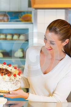Female baker or pastry chef with torte photo
