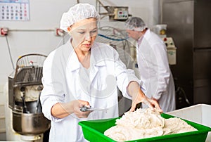 Female baker portioning dough