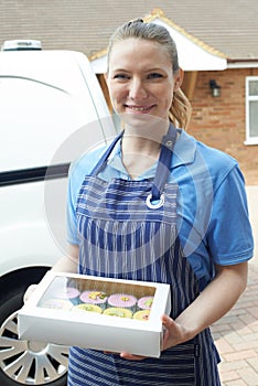 Female Baker Standing Next To Van Making Home Delivery Of Cupcakes